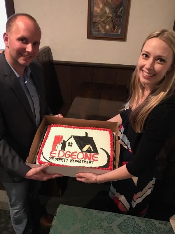Two people holding a cake with 