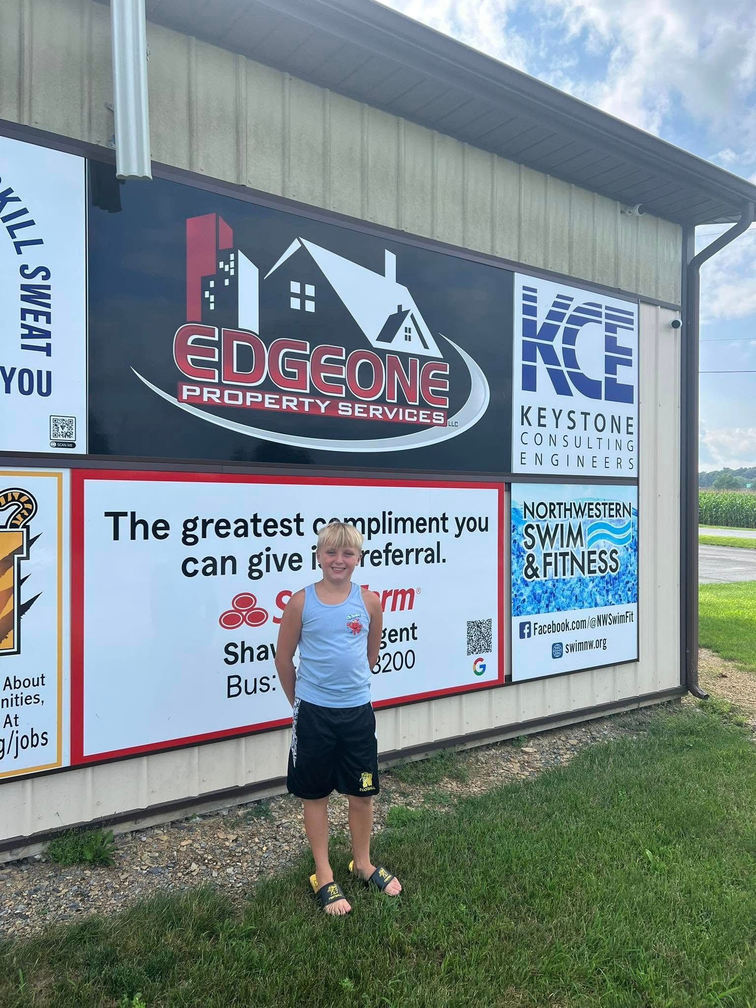 Boy standing in front of building with signs, including 