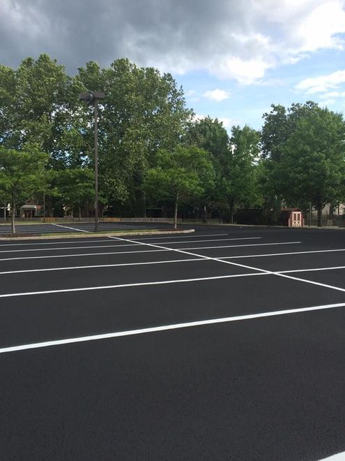 An empty parking lot with trees in the background