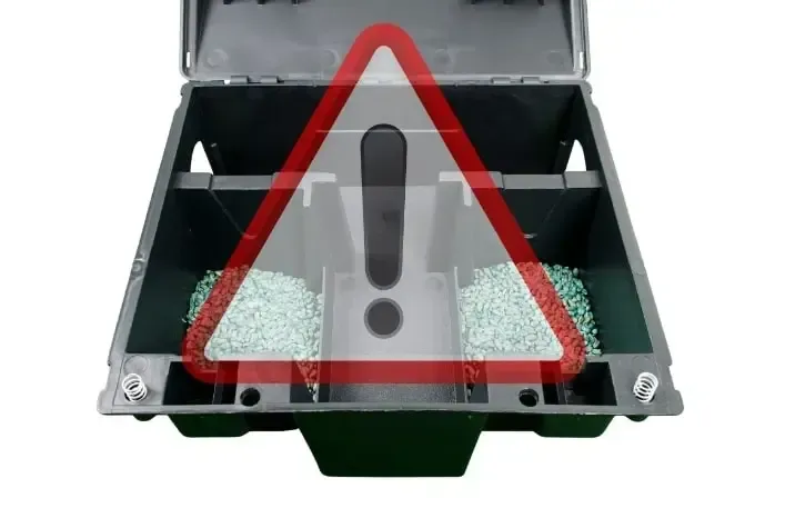 Un boîtier à rat contenant du raticide avec une mise en garde pour non-conformité avec la législation sur l'appâtage permanent.