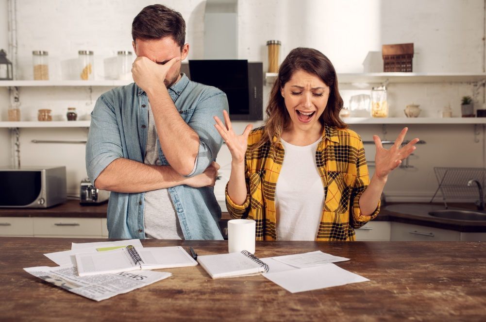 Un couple stressé par une accumulation de facture et de tâches administratives. 