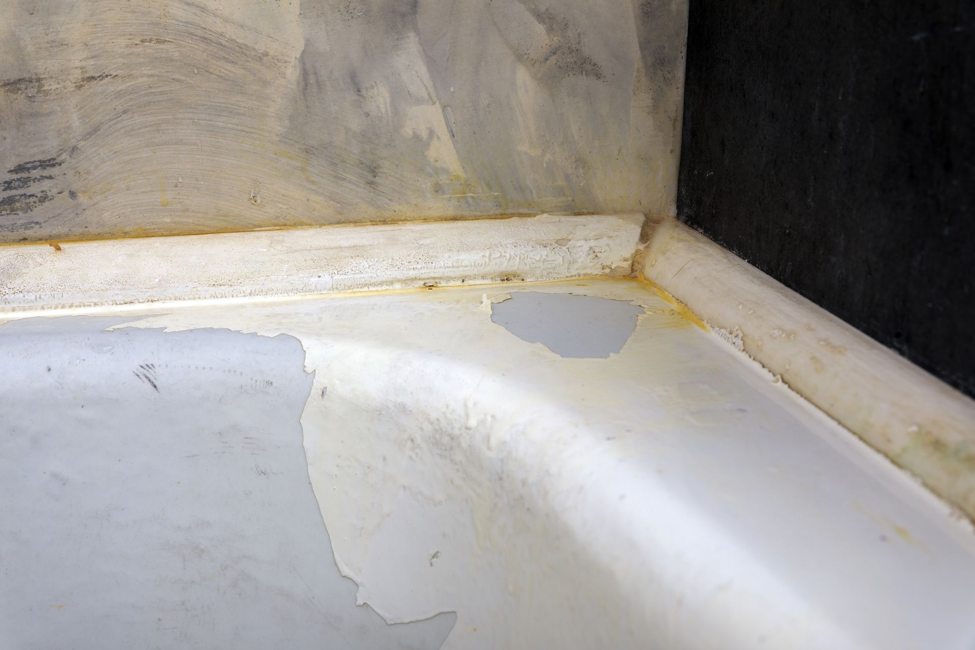 Peeling bathtub paint close-up.