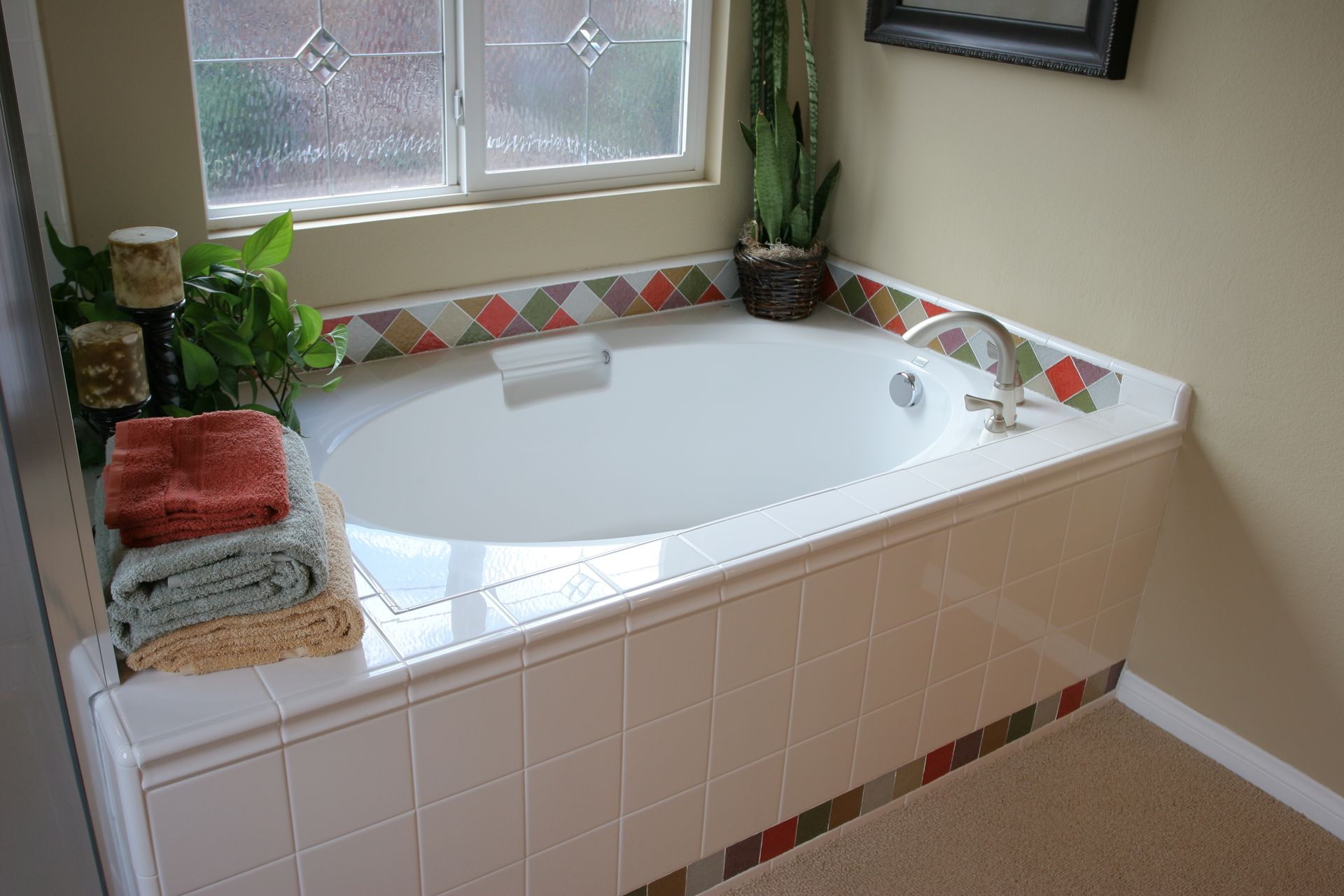 A finished bathtub makeover with multi-colored tiles. A finished bathtub makeover with multi-colored tiles.