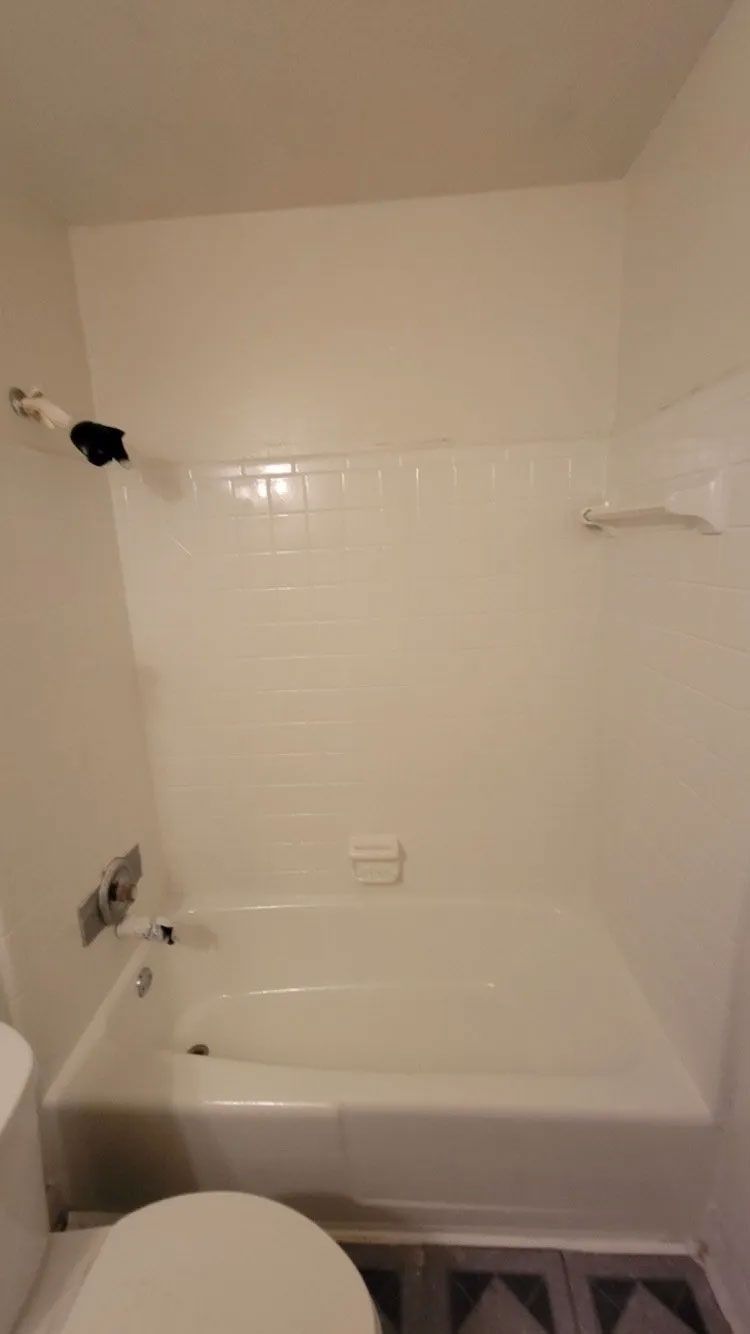 A bathroom featuring a bathtub and tile wall after remodeling.