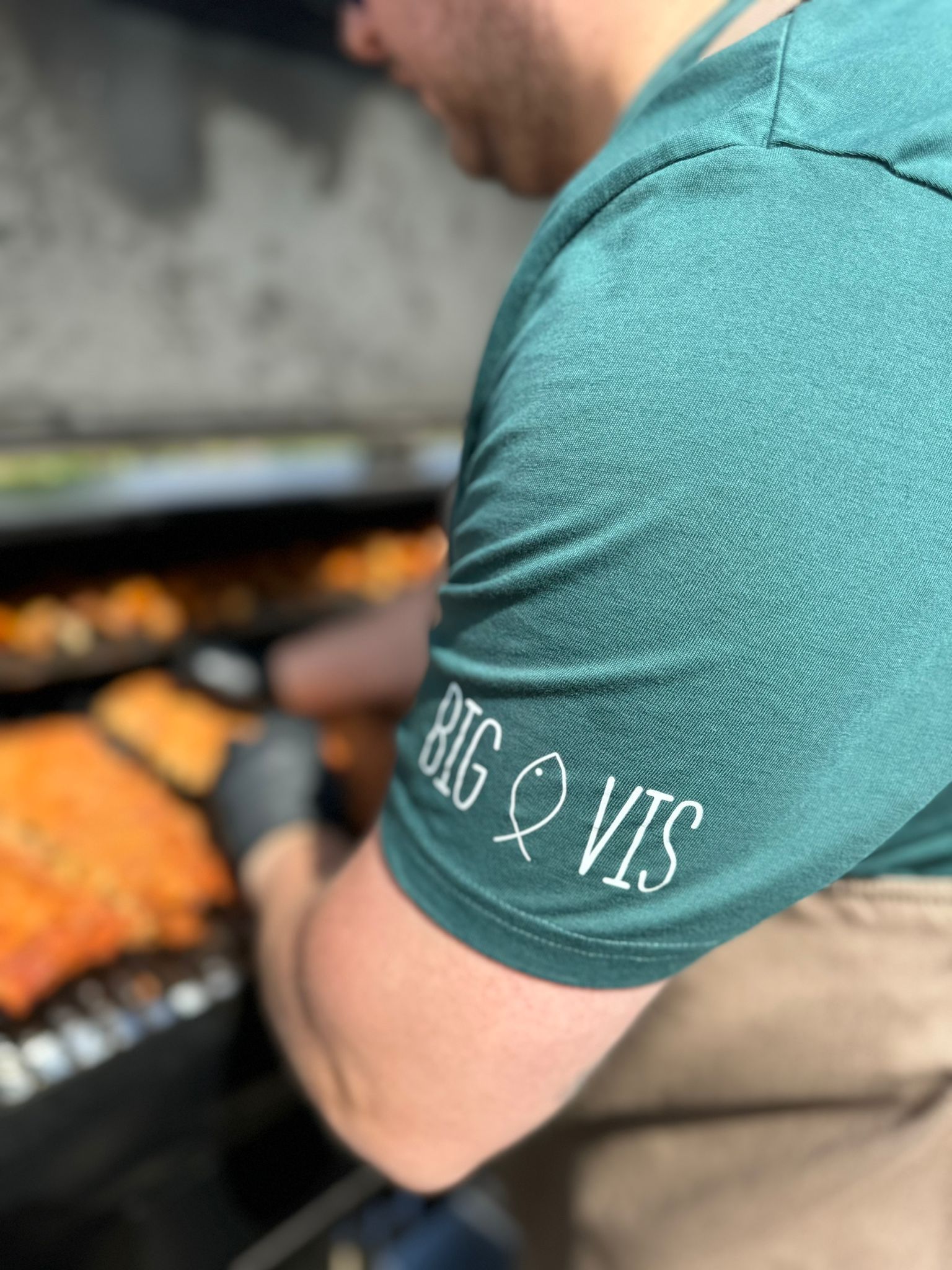 Een man met een groen shirt met de tekst big en vis