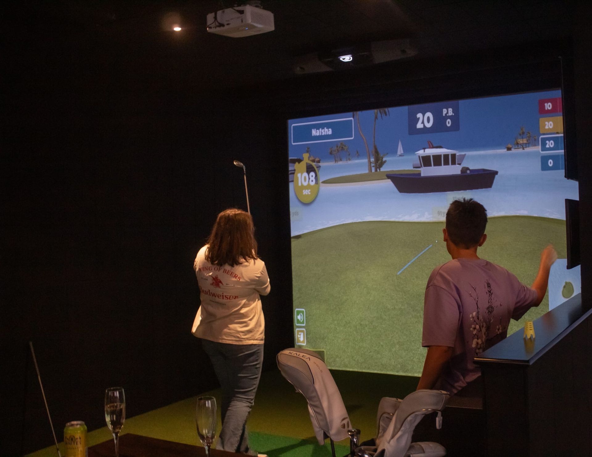 Lady golfer having a lesson on game software in a simulator