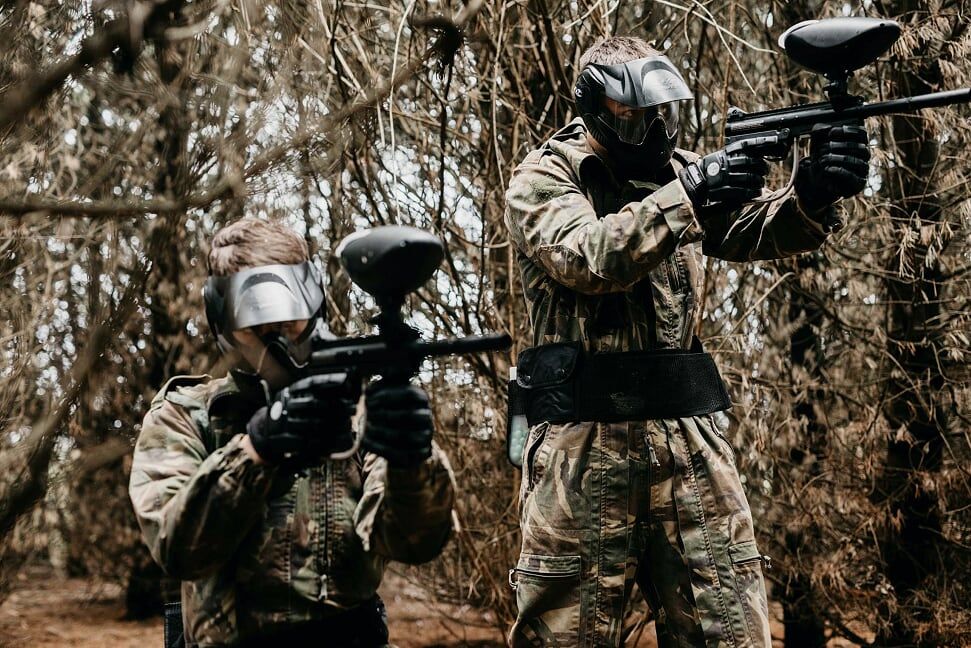 Paintball players in full gear at the shooting range