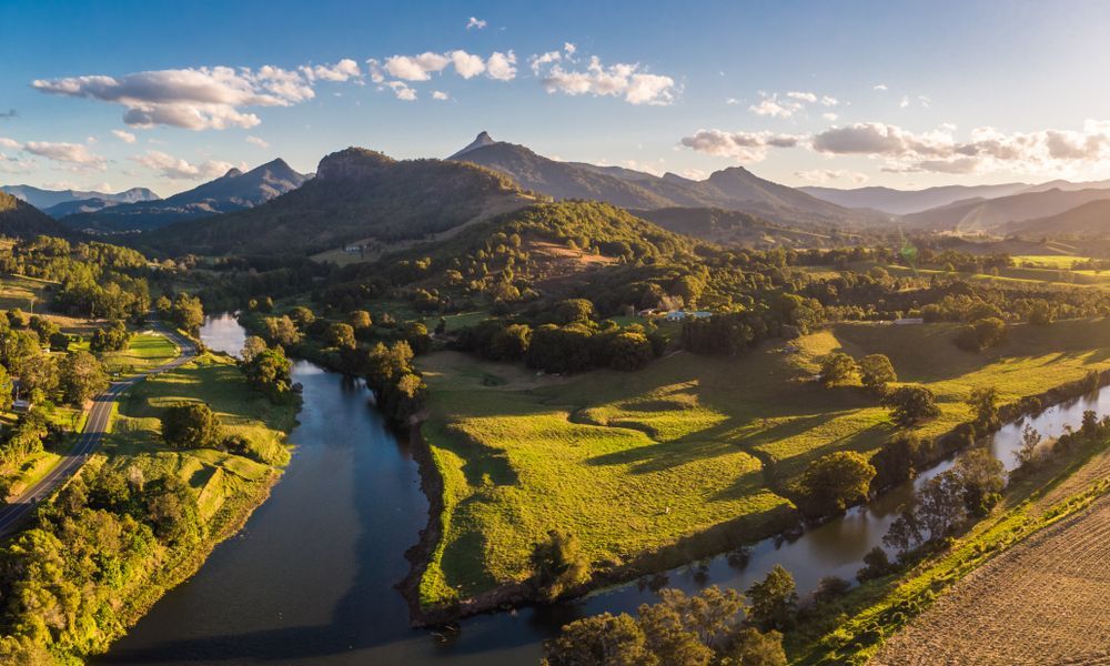 An Aerial View of a River Surrounded by Mountains and Trees — Ocean Air Electrical in Tweed Heads, NSW
