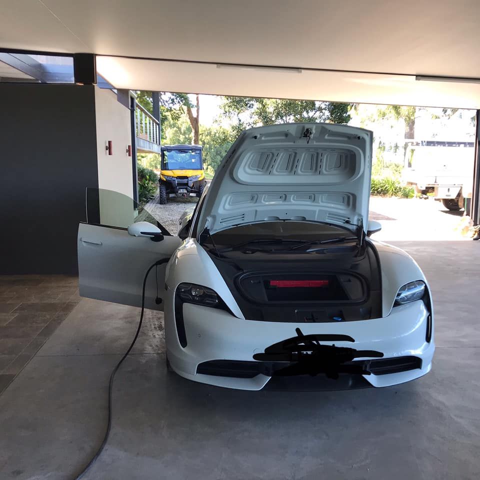 A White Electric Car With the Hood Up is Being Charged — Ocean Air Electrical in Skennars Head, NSW