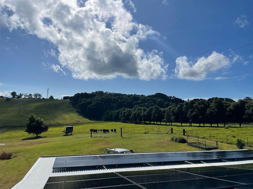 A Large Solar Panel is Installed on the Roof of a House in the Middle of a Grassy Field — Ocean Air Electrical in Evans Head, NSW