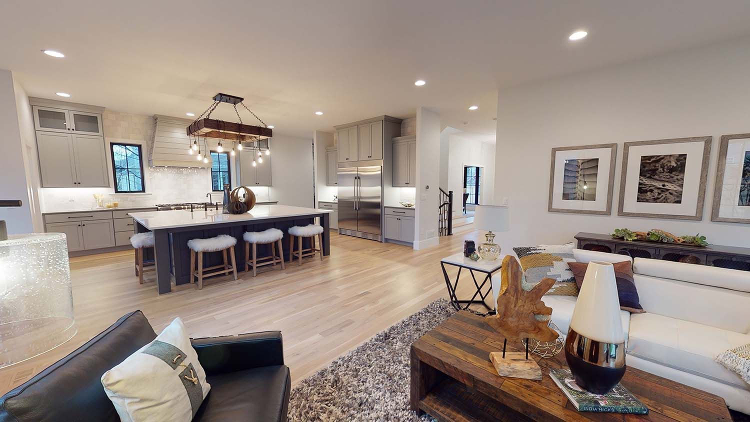 A living room with a couch , chair , coffee table and kitchen.