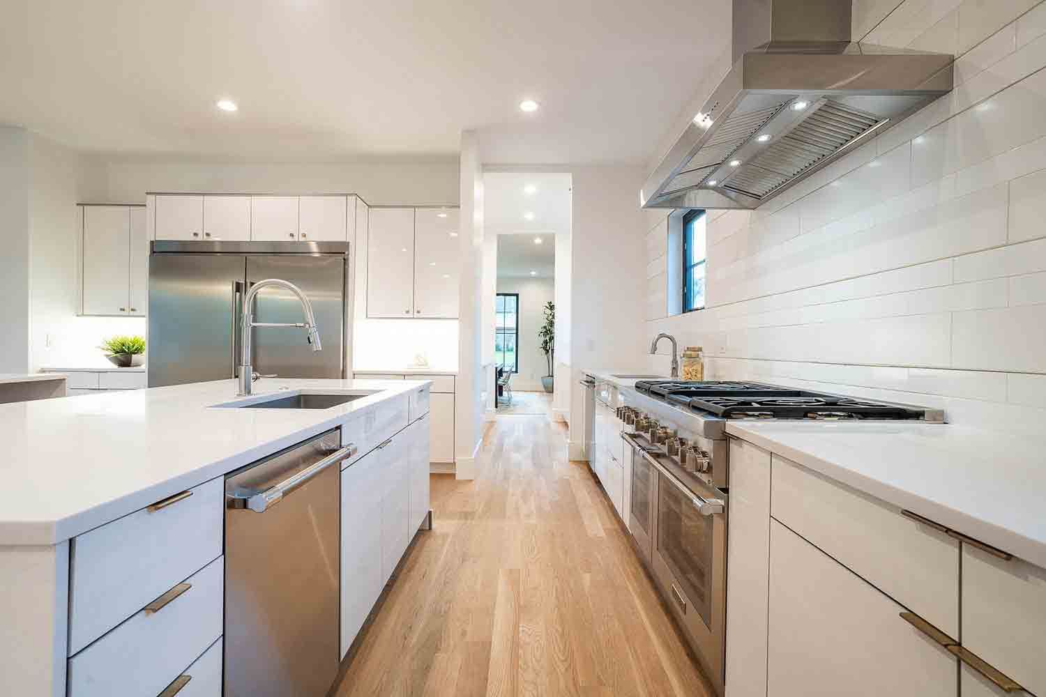 A kitchen with white cabinets and stainless steel appliances.