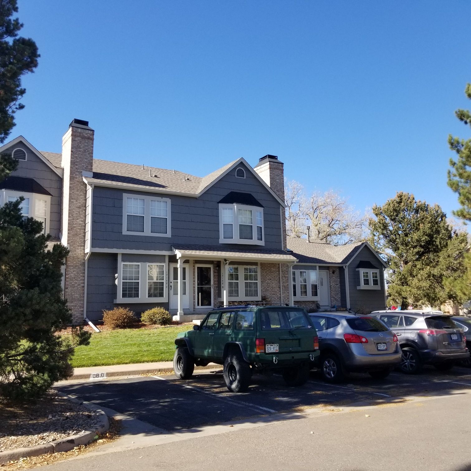 A house with a lot of cars parked in front of it