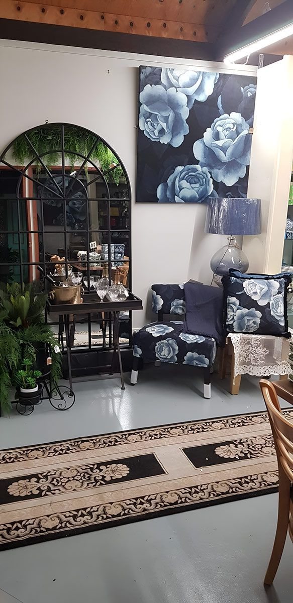 Interior with a mirror, small couch, art, and patterned rug.