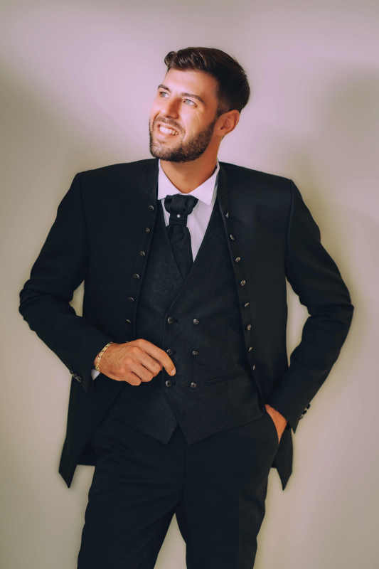 Un uomo in giacca e cravatta con le mani in tasca