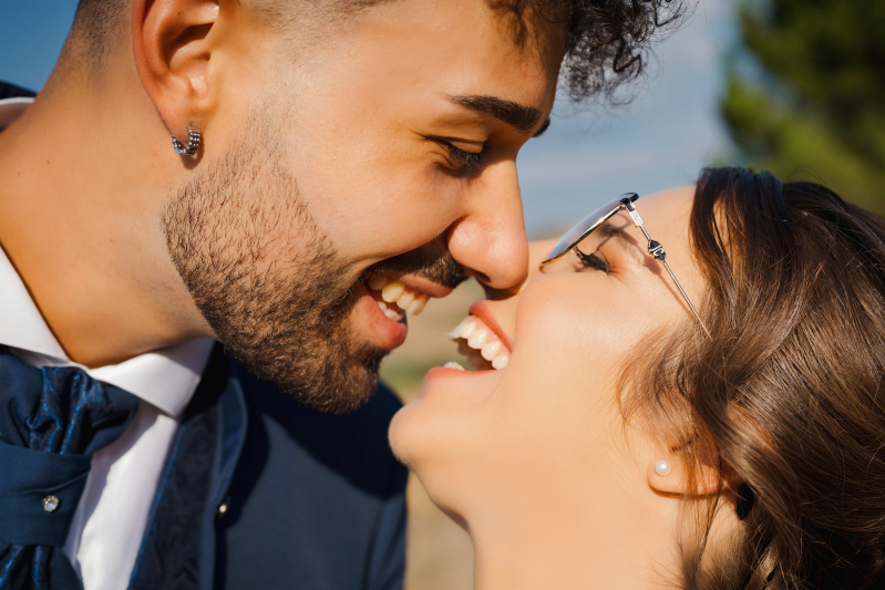 Una sposa e uno sposo si baciano sul naso.