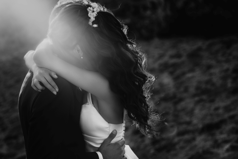 Una foto in bianco e nero di una sposa e uno sposo che si abbracciano.