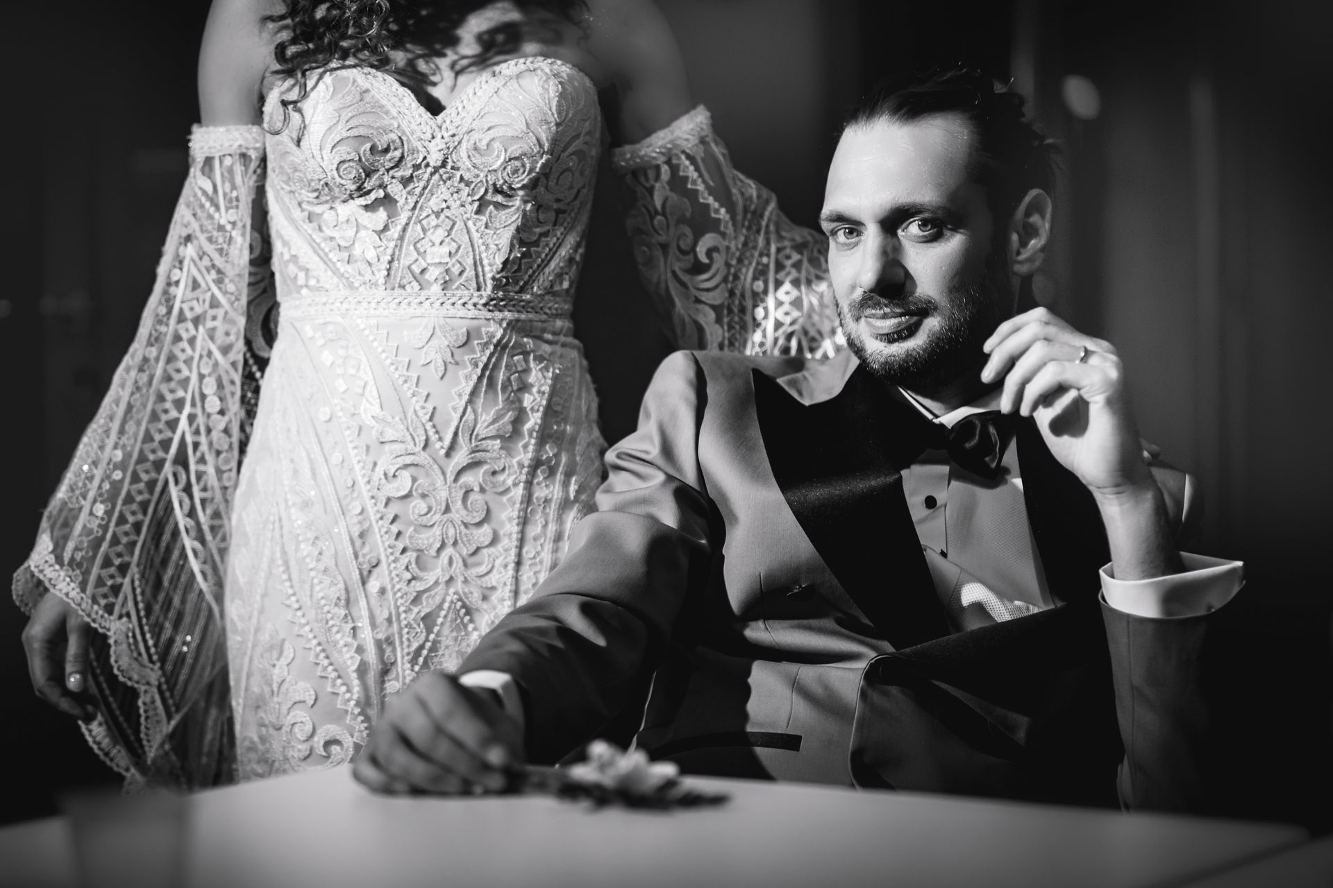 Una foto in bianco e nero di una sposa e uno sposo seduti a un tavolo.