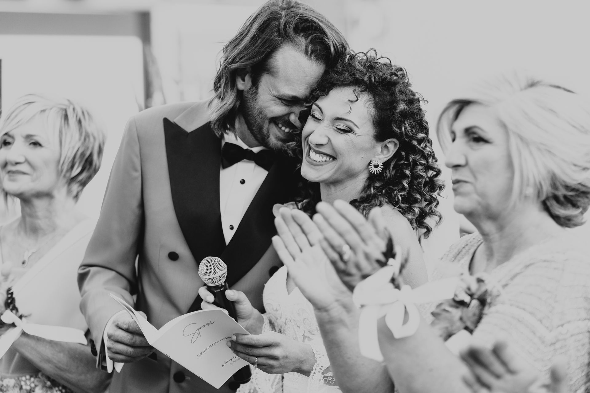 Una foto in bianco e nero di una sposa e uno sposo durante la cerimonia di nozze.