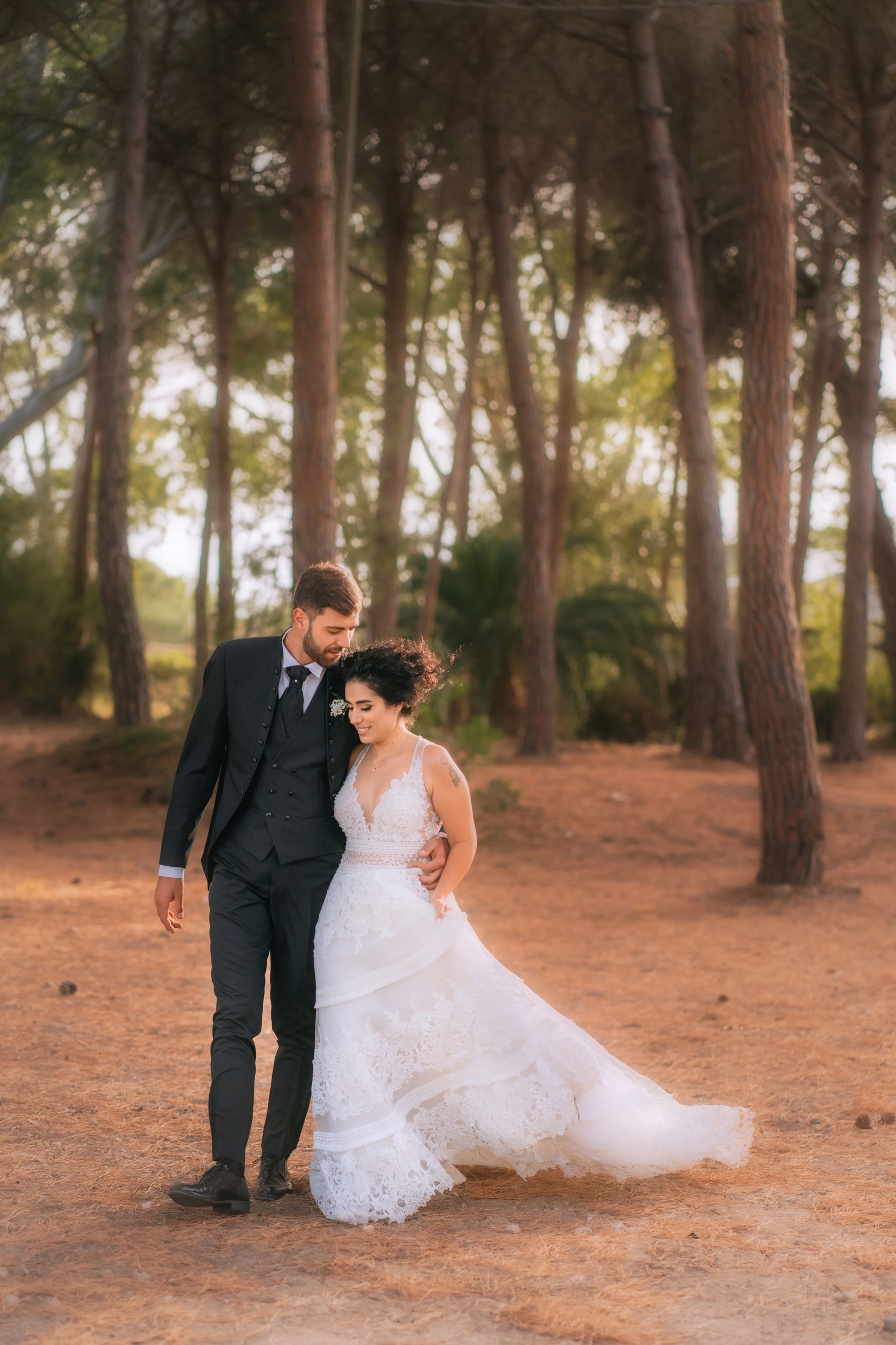 Una sposa e uno sposo stanno camminando in una foresta.