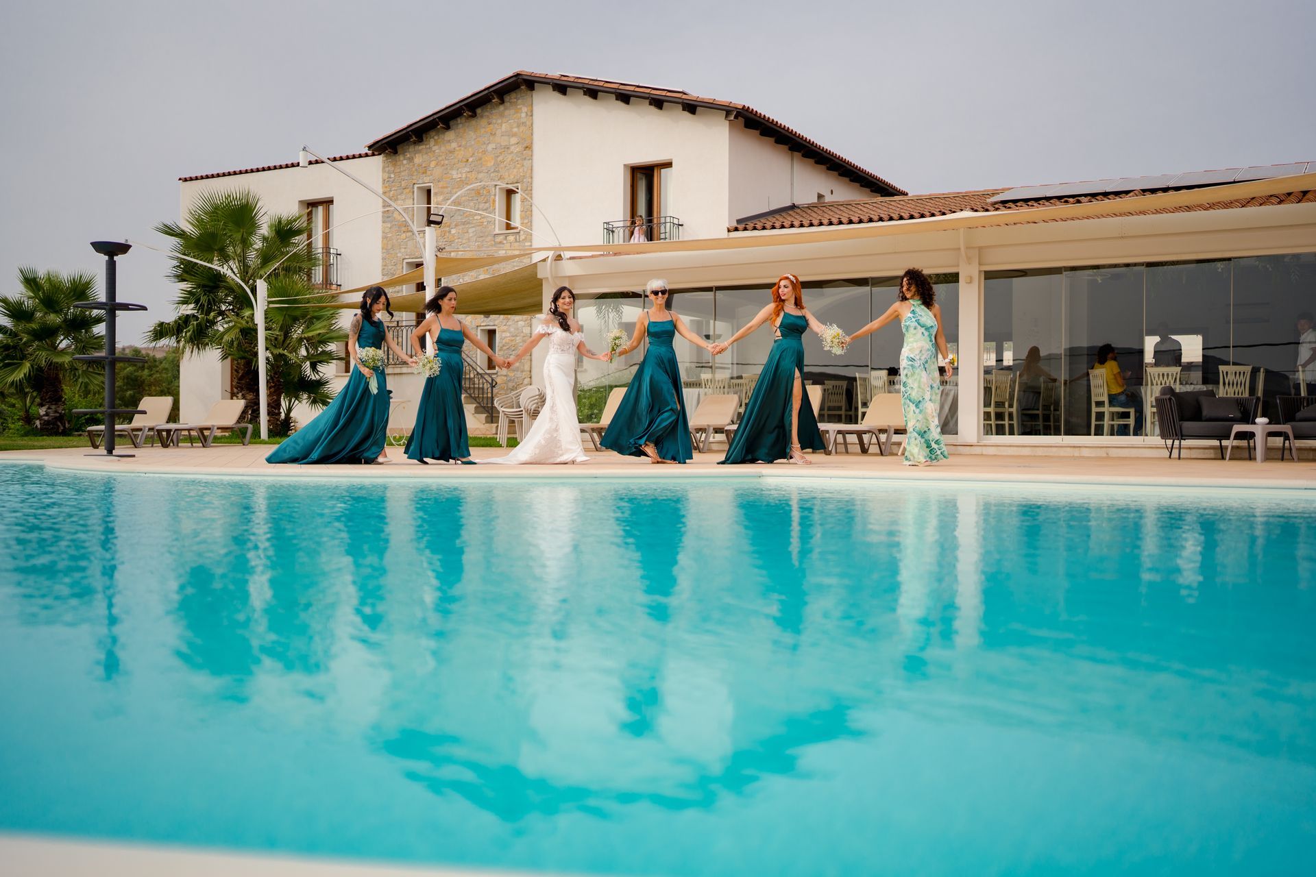 Un gruppo di donne è in piedi accanto a una piscina.
