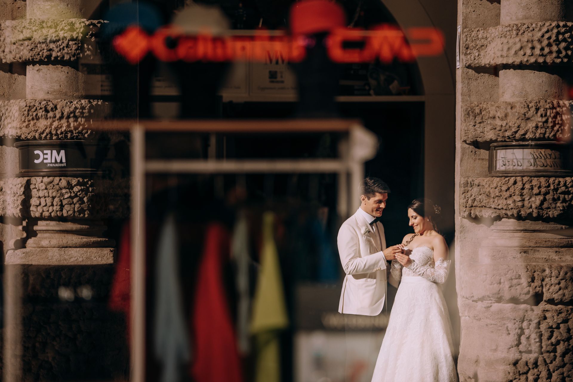 Una coppia di sposi sono in piedi davanti a un negozio.