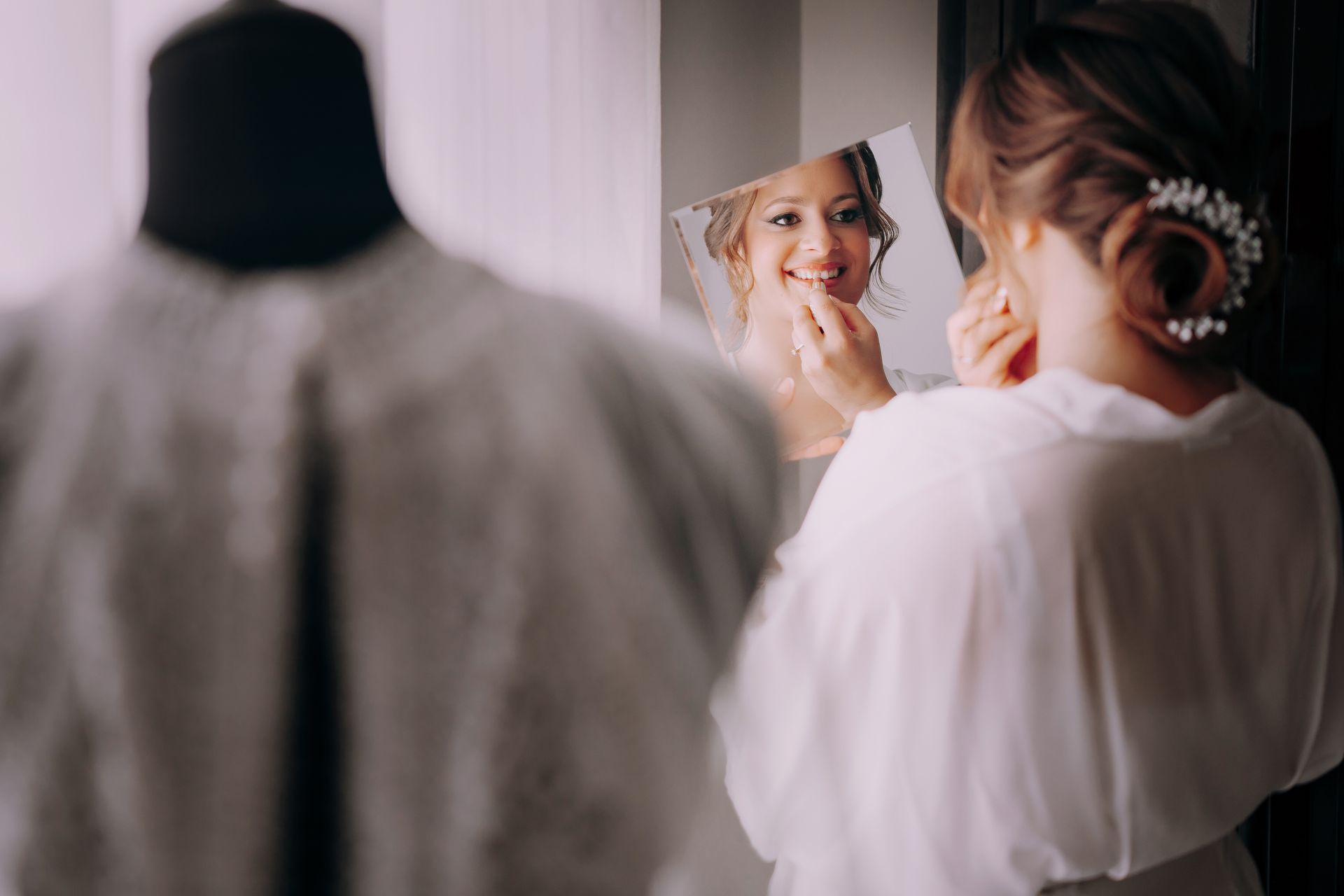 Una donna guarda il suo riflesso in uno specchio.