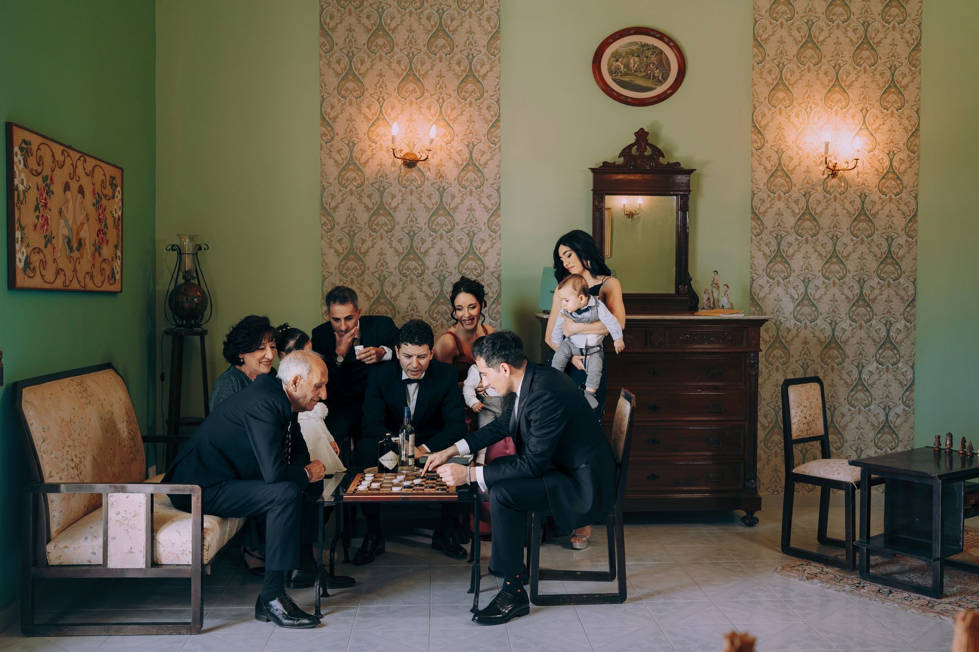 Un gruppo di persone è seduto attorno a un tavolo e gioca a scacchi.