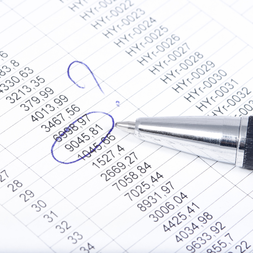 A pen is sitting on top of a spreadsheet with numbers written on it