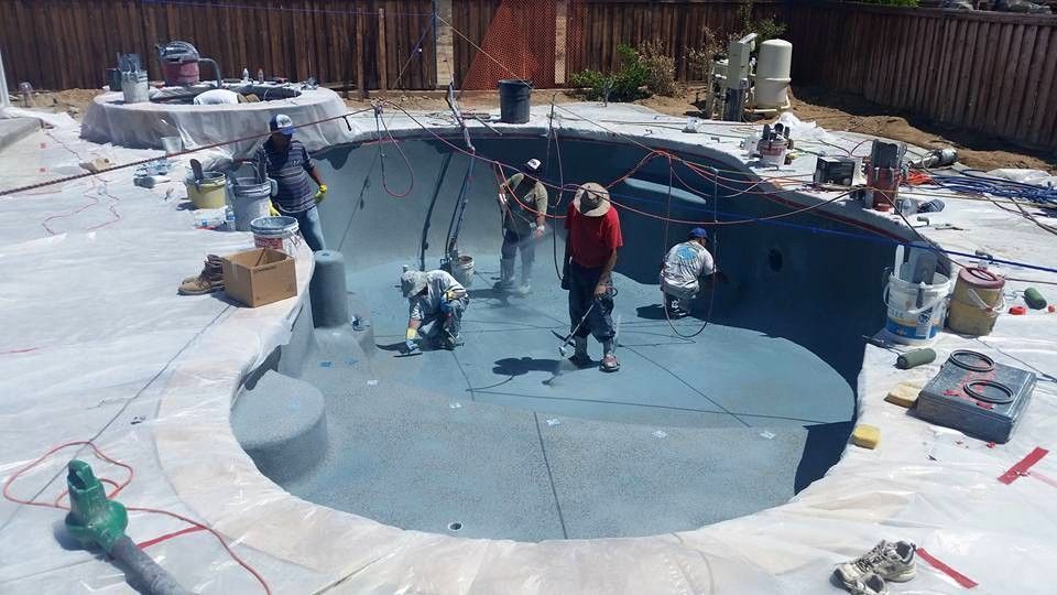 A group of people are working on a swimming pool.
