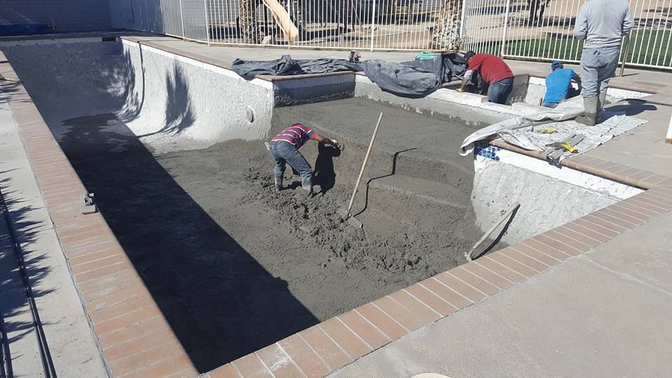 A group of men are working on a swimming pool.
