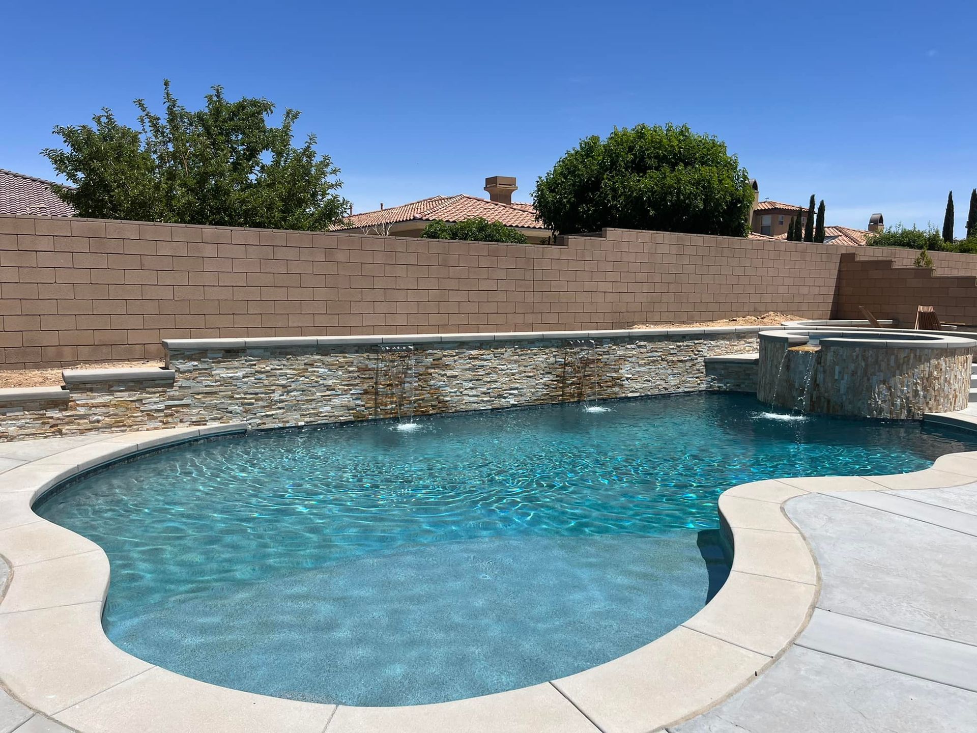 A large swimming pool with a brick wall surrounding it