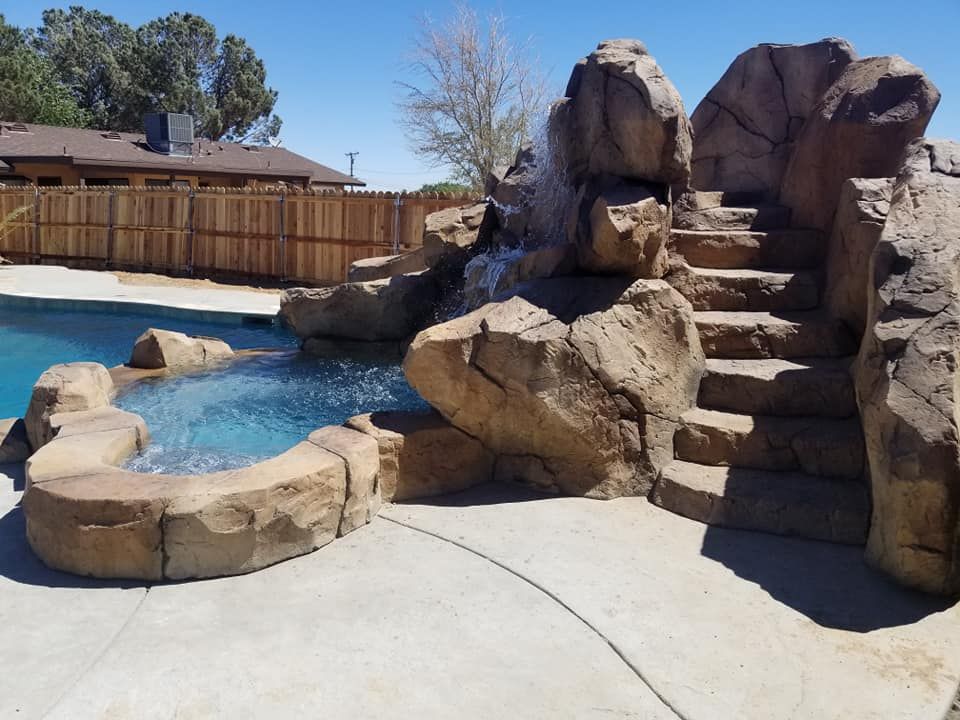 A swimming pool with a waterfall and stairs