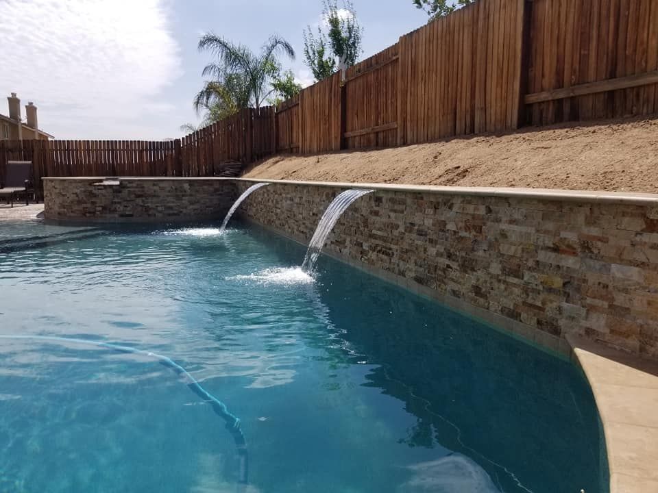 A swimming pool with a waterfall in the middle of it