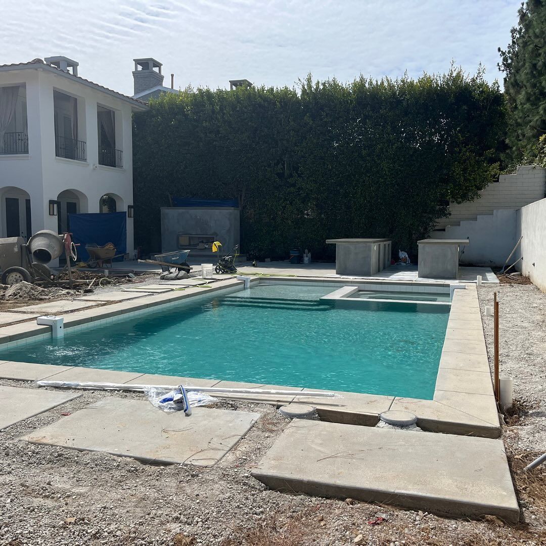 A large swimming pool is being built in the backyard of a house