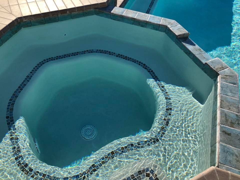 A hot tub in the middle of a swimming pool.