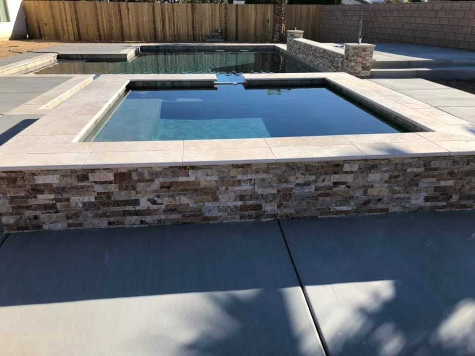 A swimming pool with a stone wall surrounding it