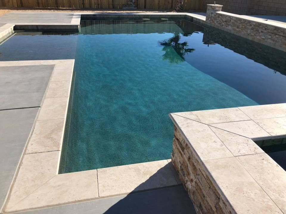 A large swimming pool with a palm tree reflected in the water.