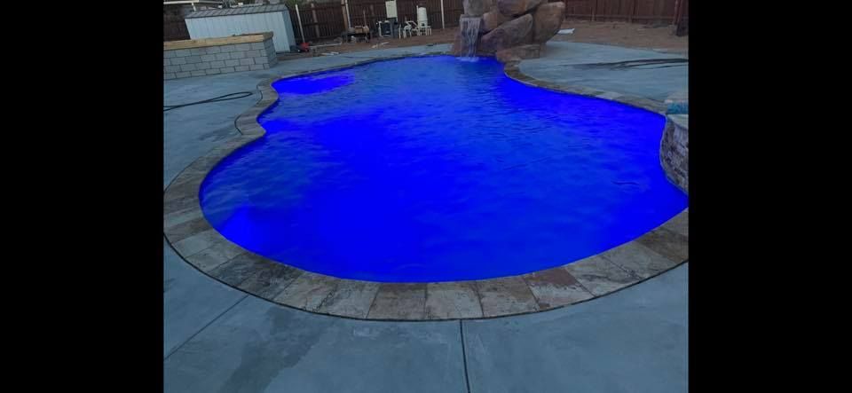 A large swimming pool with blue lights on it.
