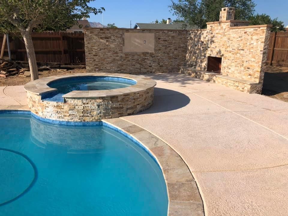A swimming pool with a hot tub and a fireplace in the backyard.