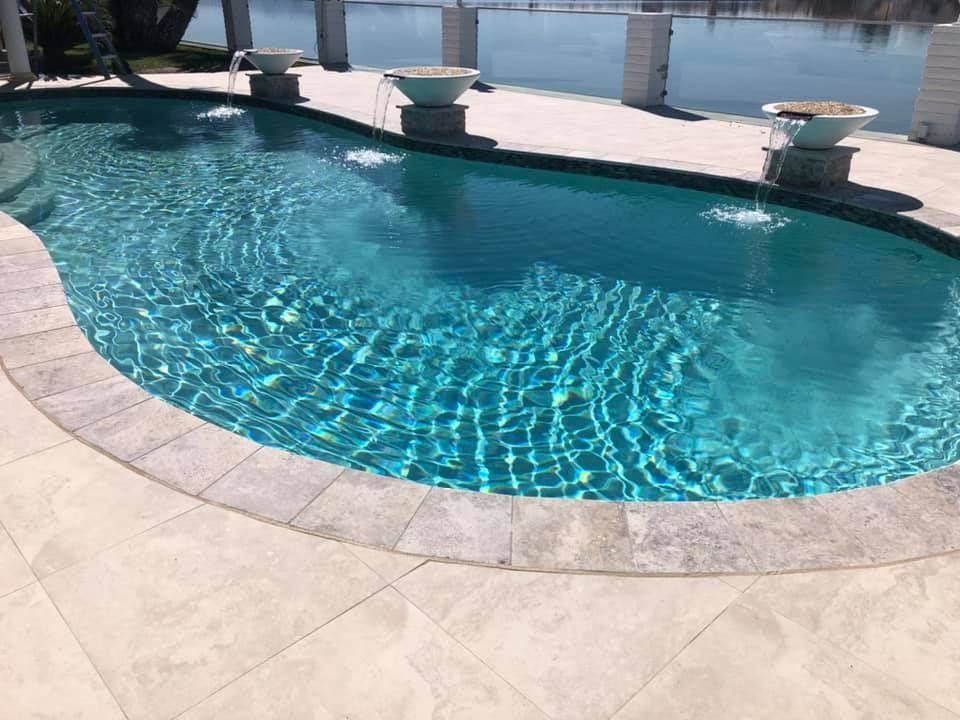A large swimming pool with a fountain in the middle of it.