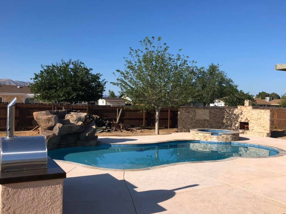 A large swimming pool is in the backyard of a house.