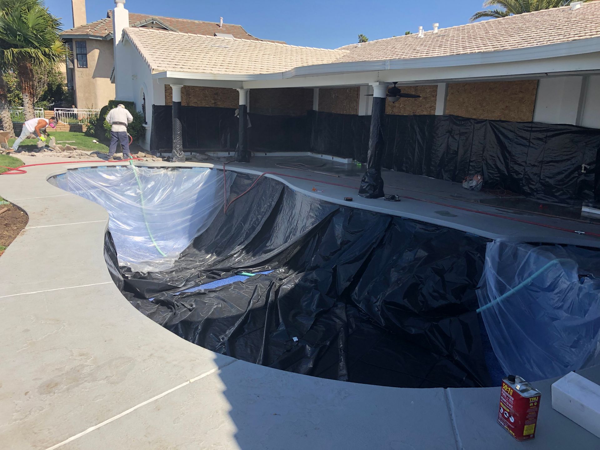 A large swimming pool is being built in front of a house.