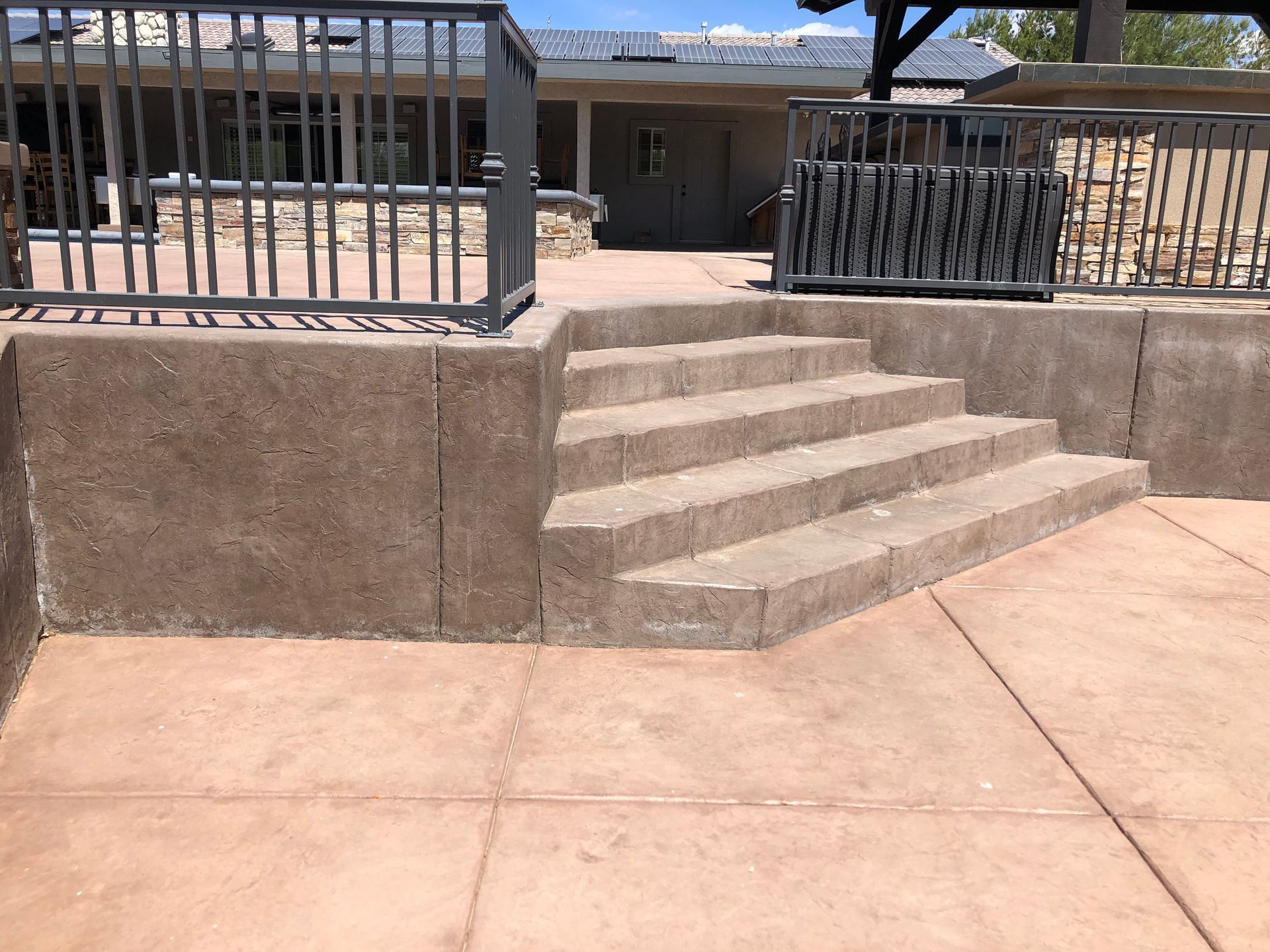 A set of stairs leading up to a house with a metal railing.