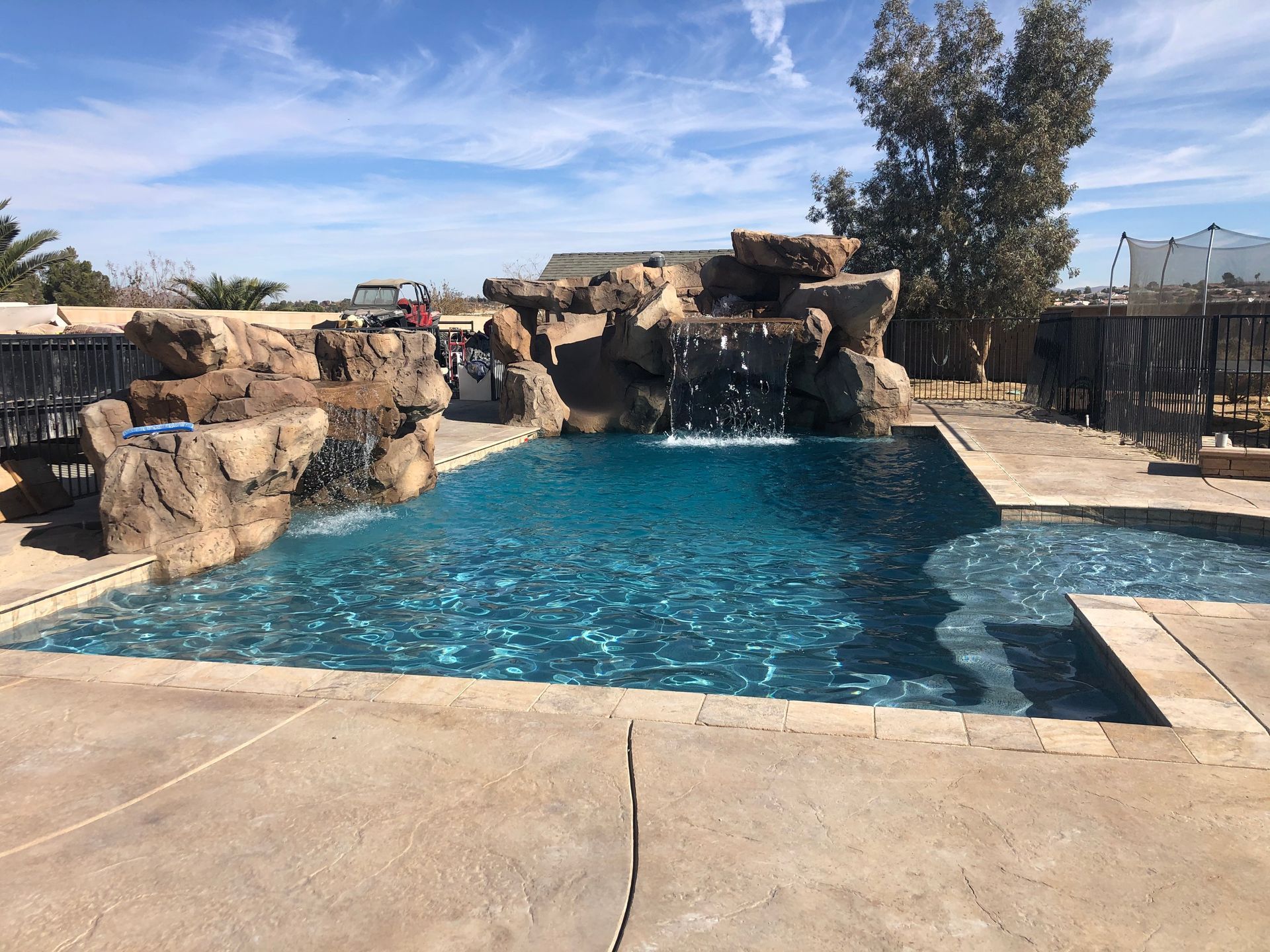 A large swimming pool with a waterfall in the middle