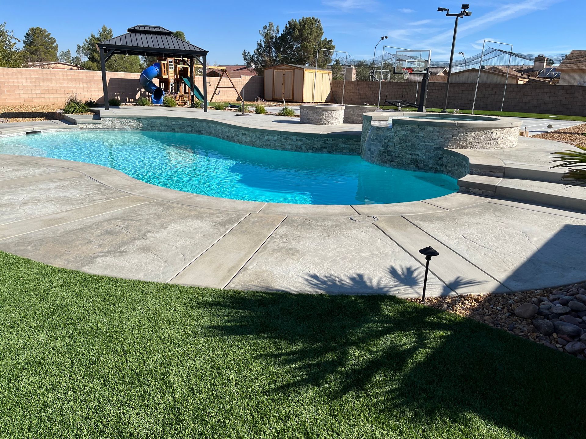 A large swimming pool with a gazebo in the background