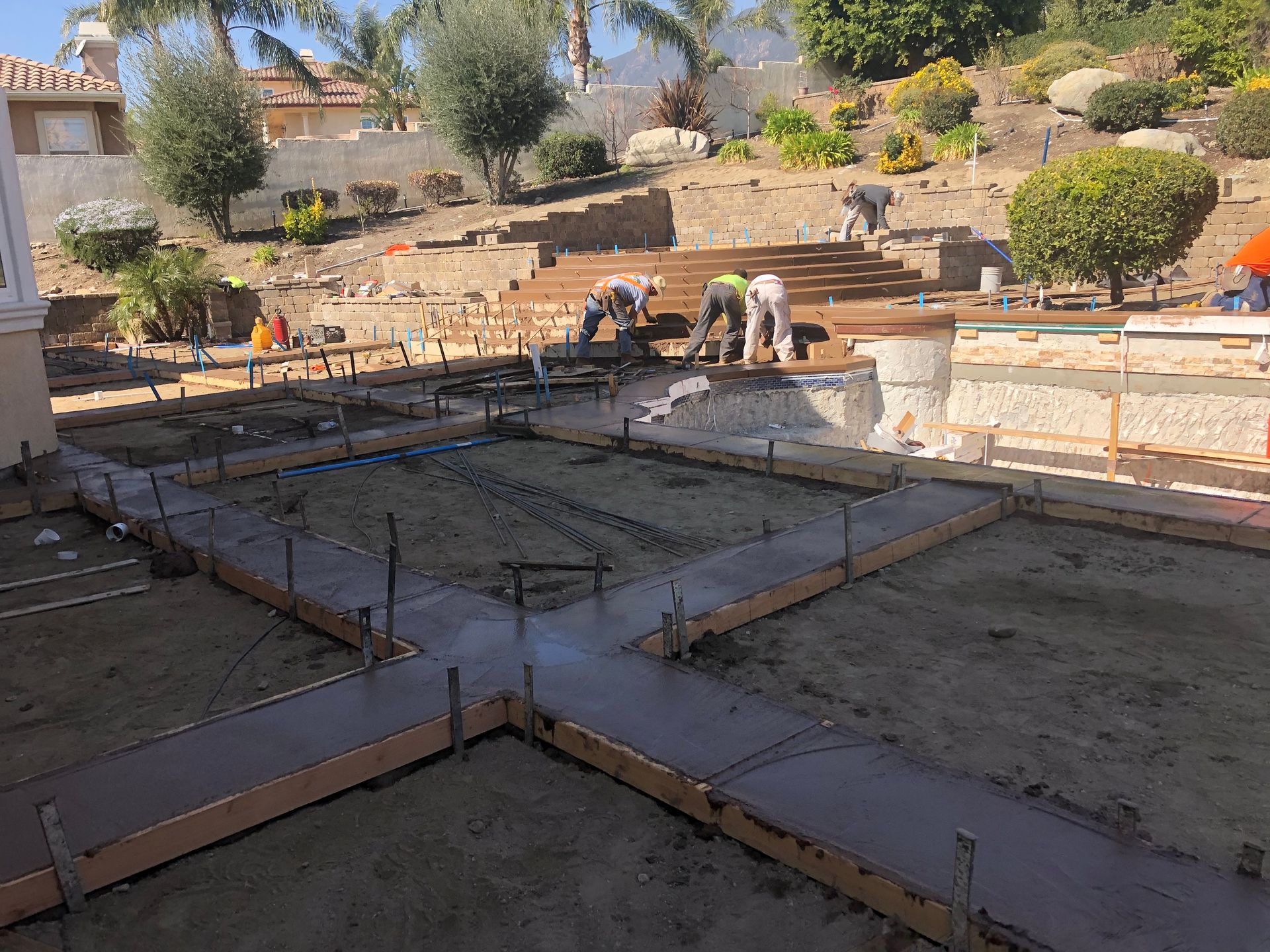 A group of construction workers are working on a concrete floor.