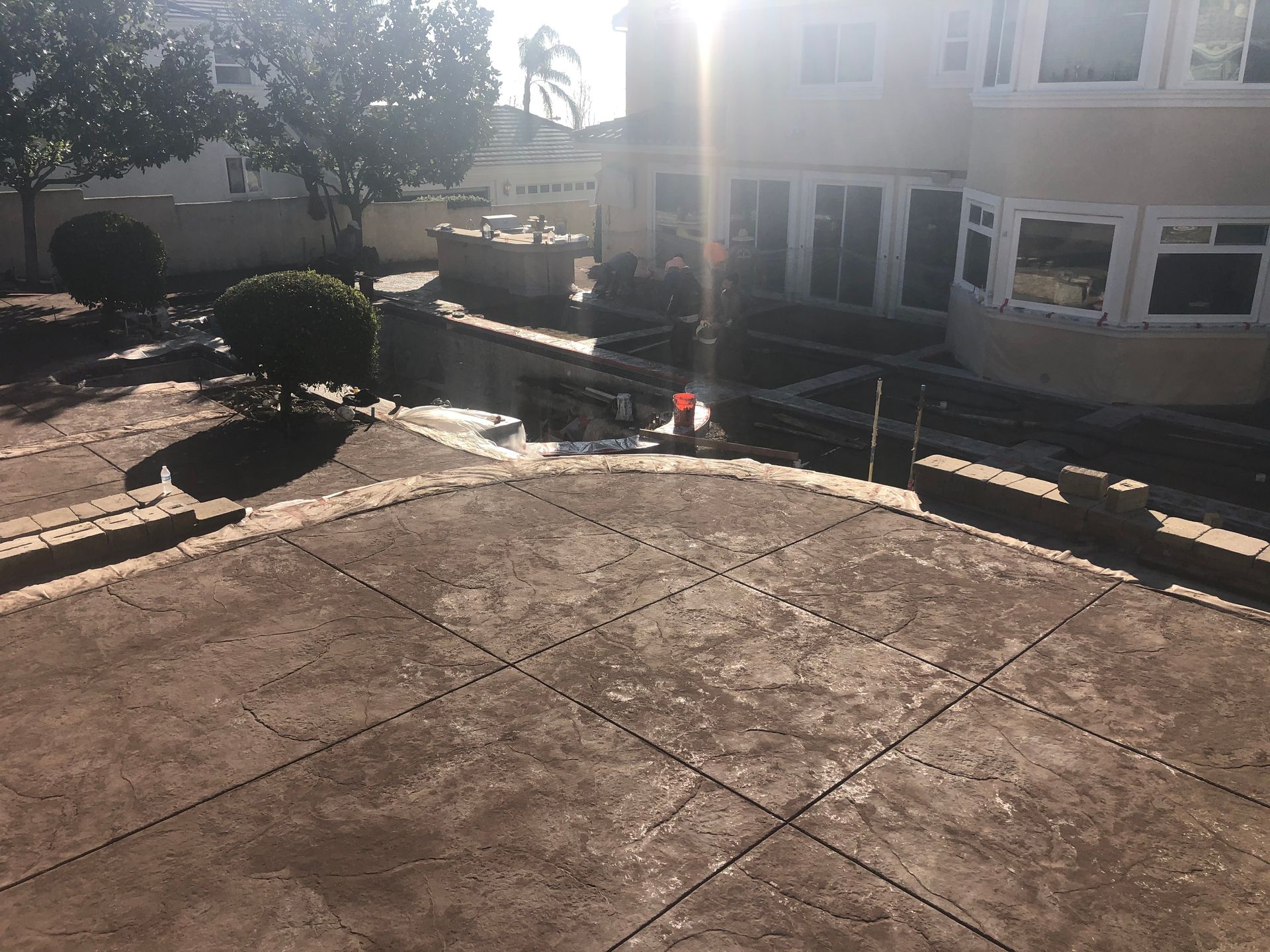 A concrete patio with a large house in the background.