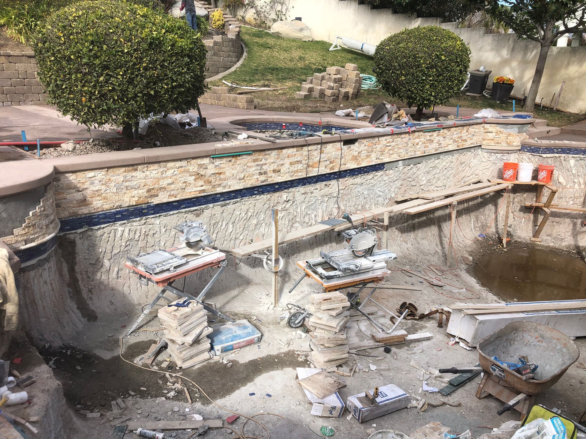 A swimming pool is being remodeled in a backyard.