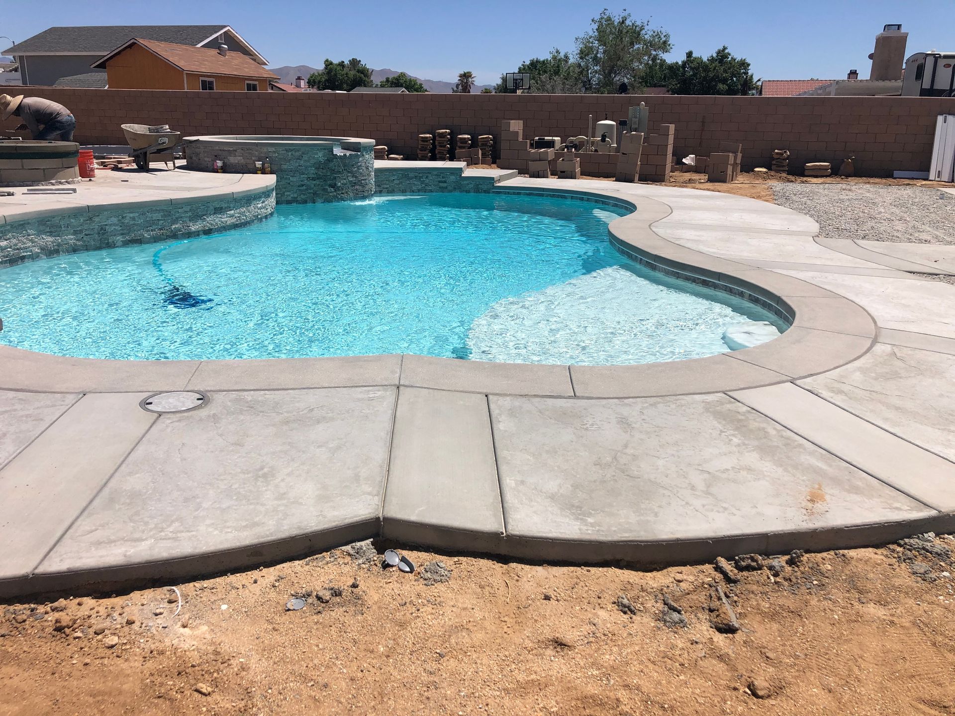 A large swimming pool is surrounded by a concrete deck